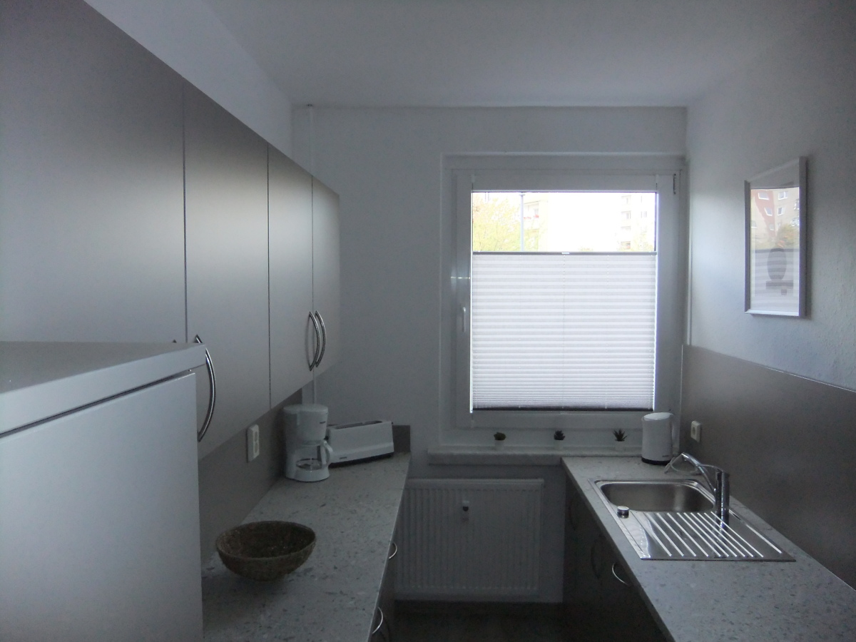 Küche mit Einbauküche und Kaffeemaschine und Wasserkocher