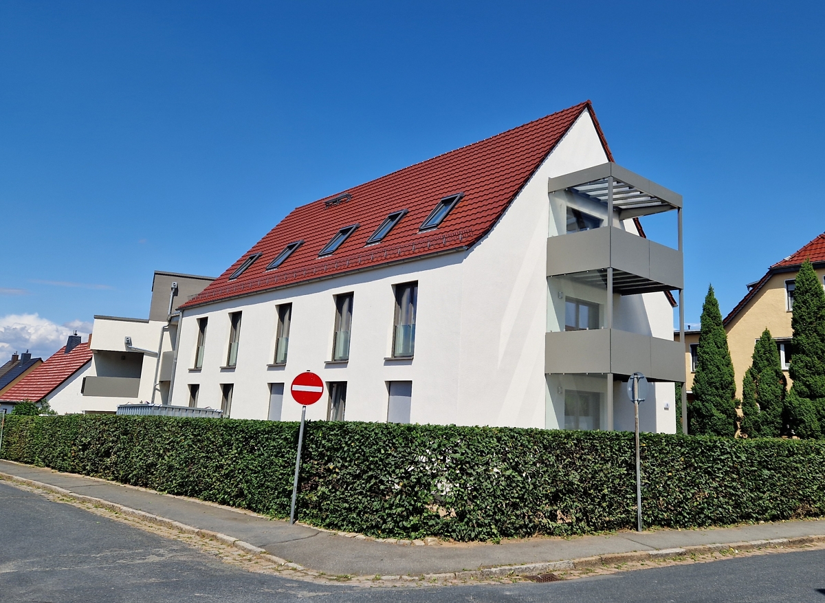 saniertes Mehrfamilienhaus mit Balkonen im grünen Grundstück